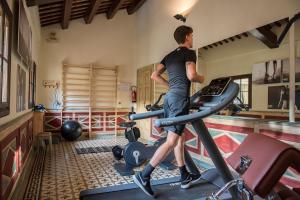 a man on a treadmill in a gym at Relais Castello Bevilacqua in Bevilacqua