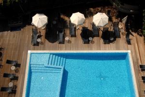 einen Blick über einen Pool mit Stühlen und Sonnenschirmen in der Unterkunft Caravel Bike Hotel in Nago-Torbole