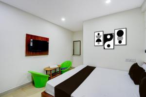 a bedroom with a bed and a table and chairs at Hotel O S V Residency in Vidya Nagar