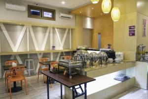 cocina con encimera con mesa y sillas en Hotel D' CaLia Tarakan, en Klapa