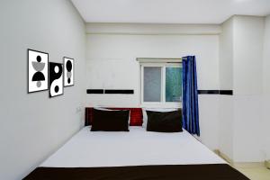 a white room with a bed and a window at Hotel O S V Residency in Vidya Nagar