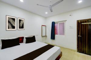 a bedroom with a bed and a window at Hotel O S V Residency in Vidya Nagar