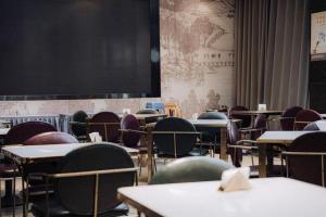 an empty classroom with tables and chairs and a blackboard at Jinjiang Metropolo Hotel Nanjing Jiangning Binjiang Development Zone in Qingxiu