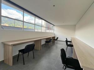 a room with chairs and a long table and a large window at Apartamento Familiar en Sabaneta cerca al parque in Sabaneta