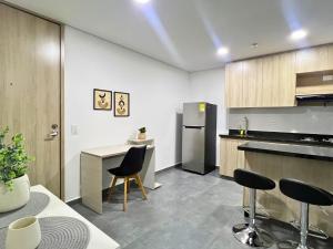 a kitchen with a counter and chairs in a room at Apartamento Familiar en Sabaneta cerca al parque in Sabaneta