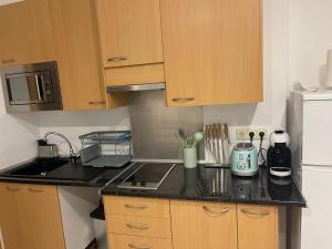 eine kleine Küche mit Spüle und Herd in der Unterkunft Encanto cuenca puerta al silencio in Cuenca