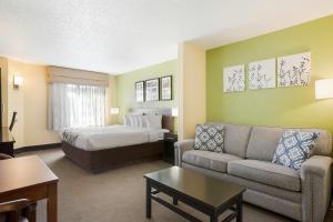 a hotel room with a bed and a couch at Sleep Inn & Suites Grand Rapids Southeast - Kentwood in Grand Rapids +33 photos