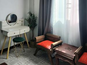 a room with a chair and a desk and a mirror at Baan Cozy Boutique Natural Wellness Chiang Mai in Chiang Mai