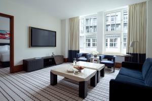 a living room with a couch and a tv at Conrad Hamburg in Hamburg