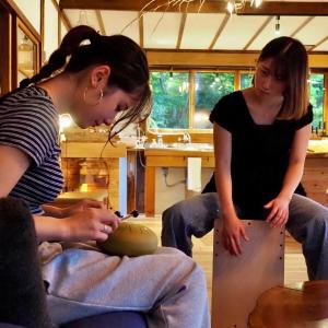 two women are working on a bowl in a room at つなぎ in Nishiwaga