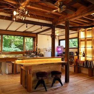 a kitchen with a large wooden table and two stools at つなぎ in Nishiwaga