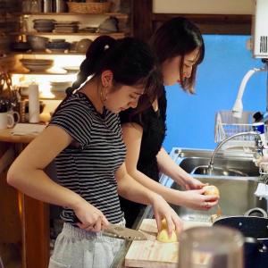 two women standing in a kitchen preparing food at つなぎ in Nishiwaga
