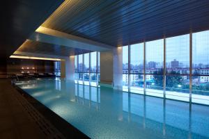 a large swimming pool in a building with a large window at Renaissance Shanghai Putuo Hotel in Shanghai