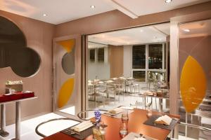a restaurant with tables and chairs in a room at Elysion Place Hotel Causeway Bay in Hong Kong