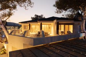 a house with a deck with chairs on it at Beau Rivage Suites in Lóngos