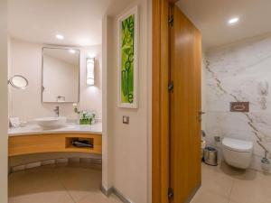 a bathroom with a sink and a toilet and a mirror at Rixos Park Belek - The Land Of Legends Access in Belek +175 photos