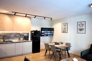 cocina y sala de estar con mesa y nevera en Antonovi Apartments Deluxe in hotel Laplandia, en Pamporovo