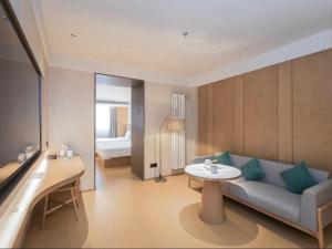 een woonkamer met een bank en een tafel bij JI Hotel Beijing Xizhimen in Beijing