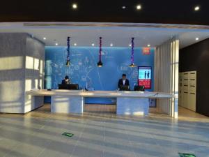 two people sitting at a desk in an office at Ibis Harbin Normal University in Harbin