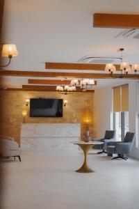 a lobby with chairs and a table and a tv at Mikheili's Marani Boutique Hotel in Kvareli
