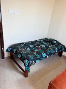 Una cama con una manta negra y azul encima en Varaham PG - Pallikaranai, en Chennai 6 fotos más