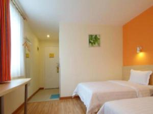a hotel room with two beds and a window at 7 Days Inn·Zhuzhou Railway Station Gongxiao Plaza in Zhuzhou