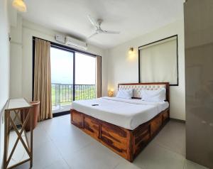 a bedroom with a large bed and a large window at Ultra Luxe 2BHK Candolim Service Apartment with River and Mangrove Views in Candolim