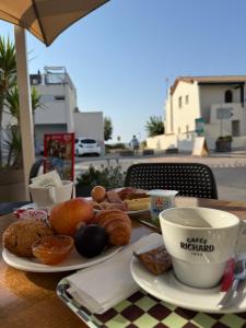 a table with plates of pastries and a cup of coffee at Hôtel Restaurant Gédéon in Carnon-Plage
