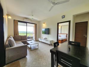 a living room with a couch and a table at Ultra Luxe 2BHK Candolim Service Apartment with River and Mangrove Views in Candolim