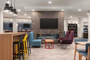 a bar with colorful chairs and a fireplace at Tru By Hilton Flagstaff in Flagstaff