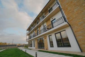 an apartment building with balconies and a lawn at Mikheili's Marani Boutique Hotel in Kvareli