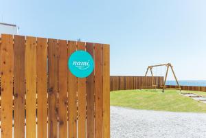 a wooden fence with a playground in a park at Lady Blue伊豆稲取 in Higashiizu