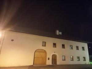a large white building with two doors at night at Hause Alpina in Bichlbach