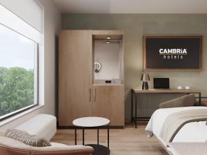 a bedroom with a bed and a table and a desk at Cambria Hotel Euless - DFW Airport South in Euless