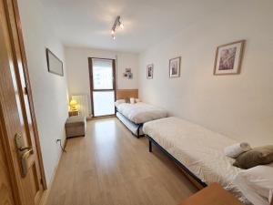 een kamer met 2 bedden en een raam erin bij Apartamentos Pilartxo Jaca 3000 in Jaca