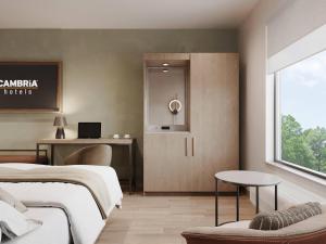 a bedroom with two beds and a desk and a window at Cambria Hotel Euless - DFW Airport South in Euless