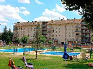 a large apartment building with a playground in a park at Apartamentos Pilartxo Jaca 3000 in Jaca