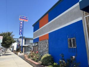 a blue and orange building with a sign on a street at Cloud 9 Inn - El Ciello Inn in Pico Rivera