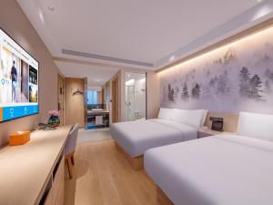 a hotel room with two beds and a desk at Orange Hotel Beijing South Railway Station South Square in Beijing