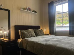 a bedroom with a large bed with a window at Nourish Reefton & Wilsons Hotel in Reefton