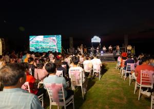 a crowd of people sitting in chairs in front of a stage at Homestay Đồi Mây Lộc Tân Bảo Lộc in Bảo Lâm