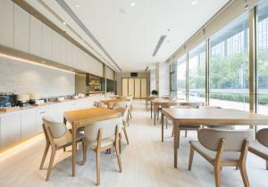 a cafeteria with tables and chairs and windows at JI Hotel Beijing Changyang Subway Station in Fangshan