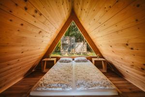 a bed in a wooden room with a window at Glamping Bizjak in Preddvor