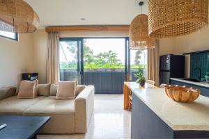 eine Küche und ein Wohnzimmer mit einer Couch und einem Tisch in der Unterkunft Stylish 1BR near Balangan Beach - Uluwatu in Bingin Beach