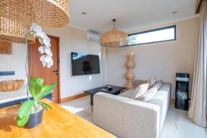 ein Wohnzimmer mit Sofa und Fernseher in der Unterkunft Stylish 1BR near Balangan Beach - Uluwatu in Bingin Beach