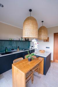 eine Küche mit einem Holztisch und zwei Pendelleuchten in der Unterkunft Stylish 1BR near Balangan Beach - Uluwatu in Bingin Beach + 18 Fotos
