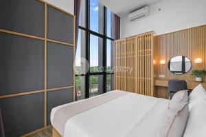 a bedroom with a white bed and a large window at Minori by Kozystay - Alam Sutera in Dongkal Dua +43 photos