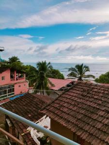 a view of the roofs of houses and the ocean at Prema guest house in Arambol