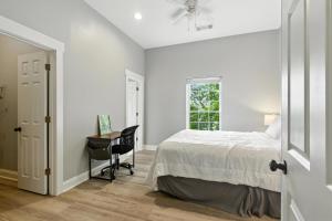 a bedroom with a bed and a desk and a window at New Listing Bulldog Borough in Downtown Athens in Athens