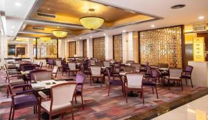 een restaurant met tafels en stoelen in een kamer bij Yangshuo Greenlotus Hotel in Yangshuo